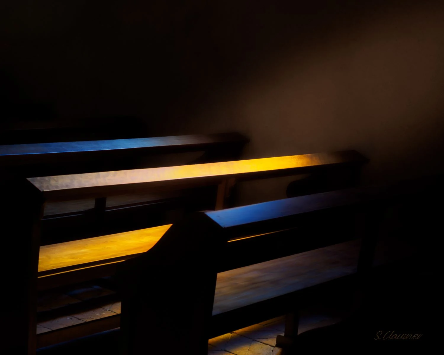 Bancs en bois traversés par des rais de lumière