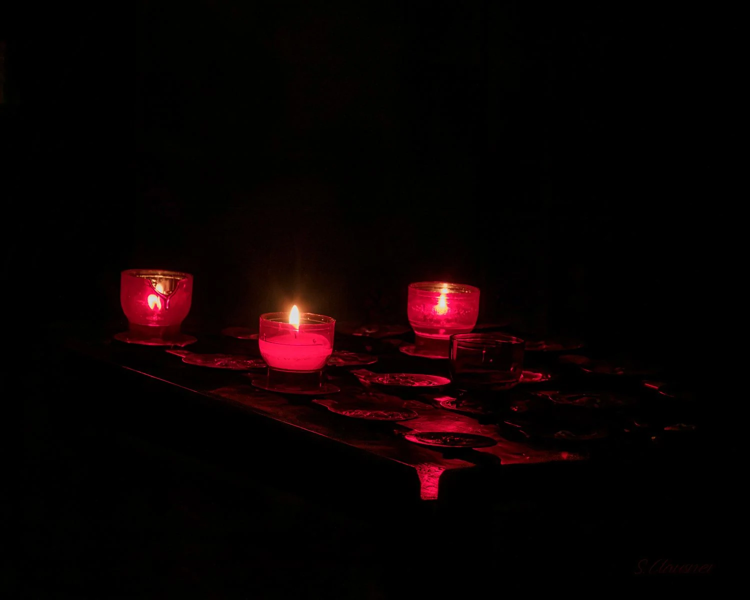 Bougies votives rouges allumées dans l’obscurité