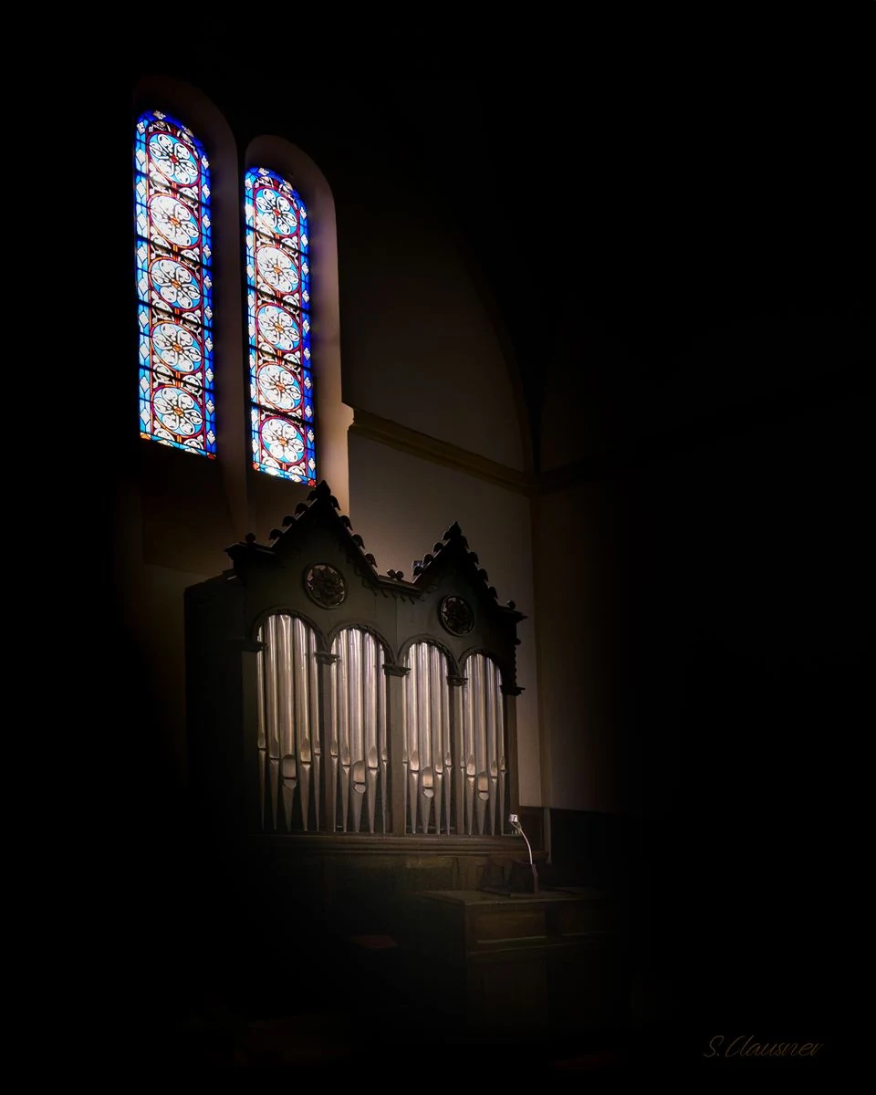 Orgue encadré par deux vitraux