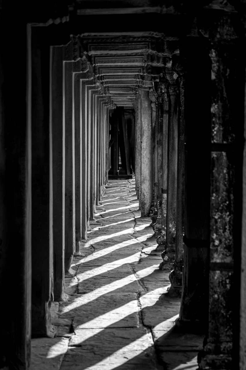 Long corridor rythmé par des colonnes et des rais de lumière